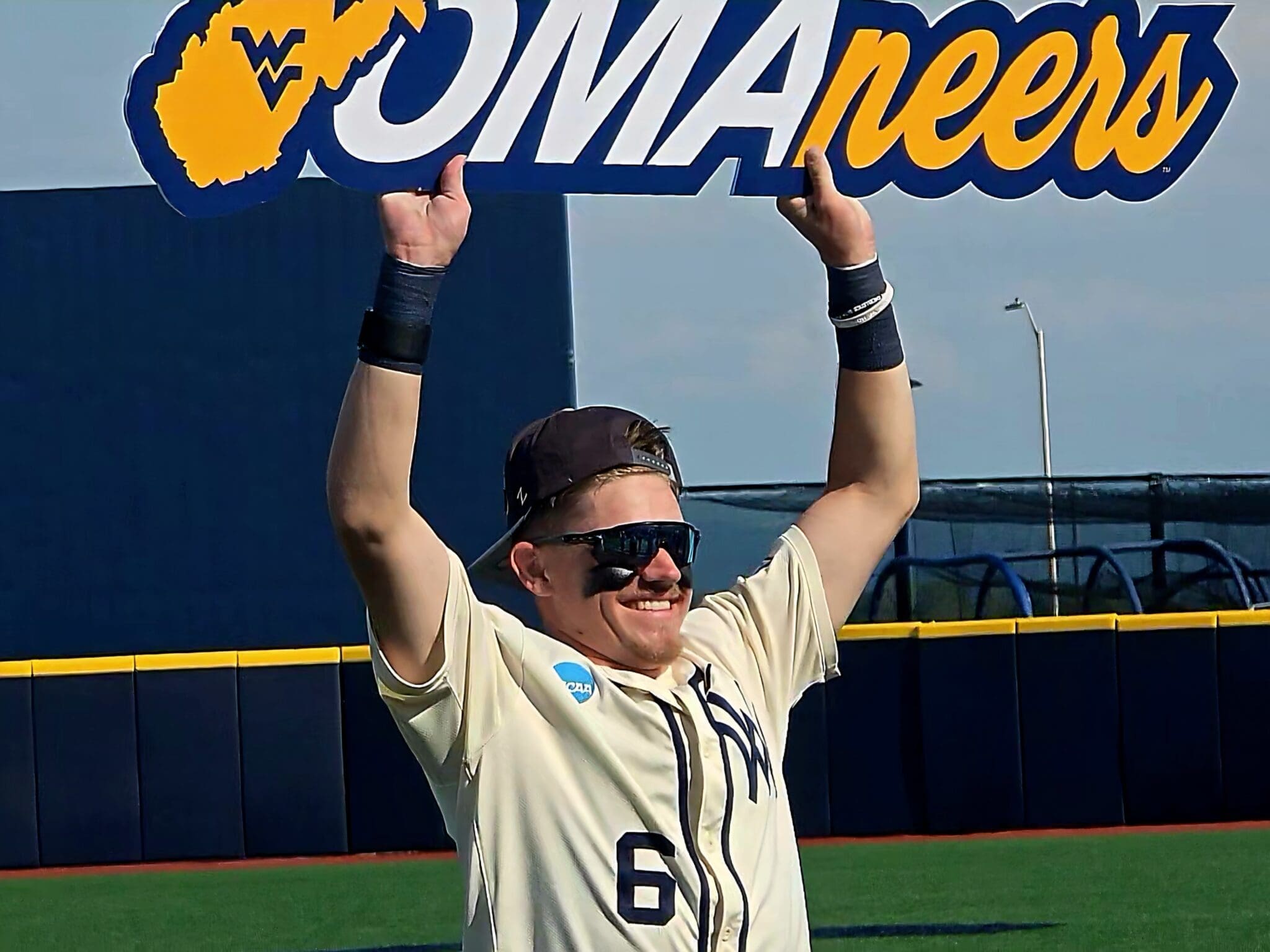 WVU Baseball Paul Schoenfeld holding Omaha sign