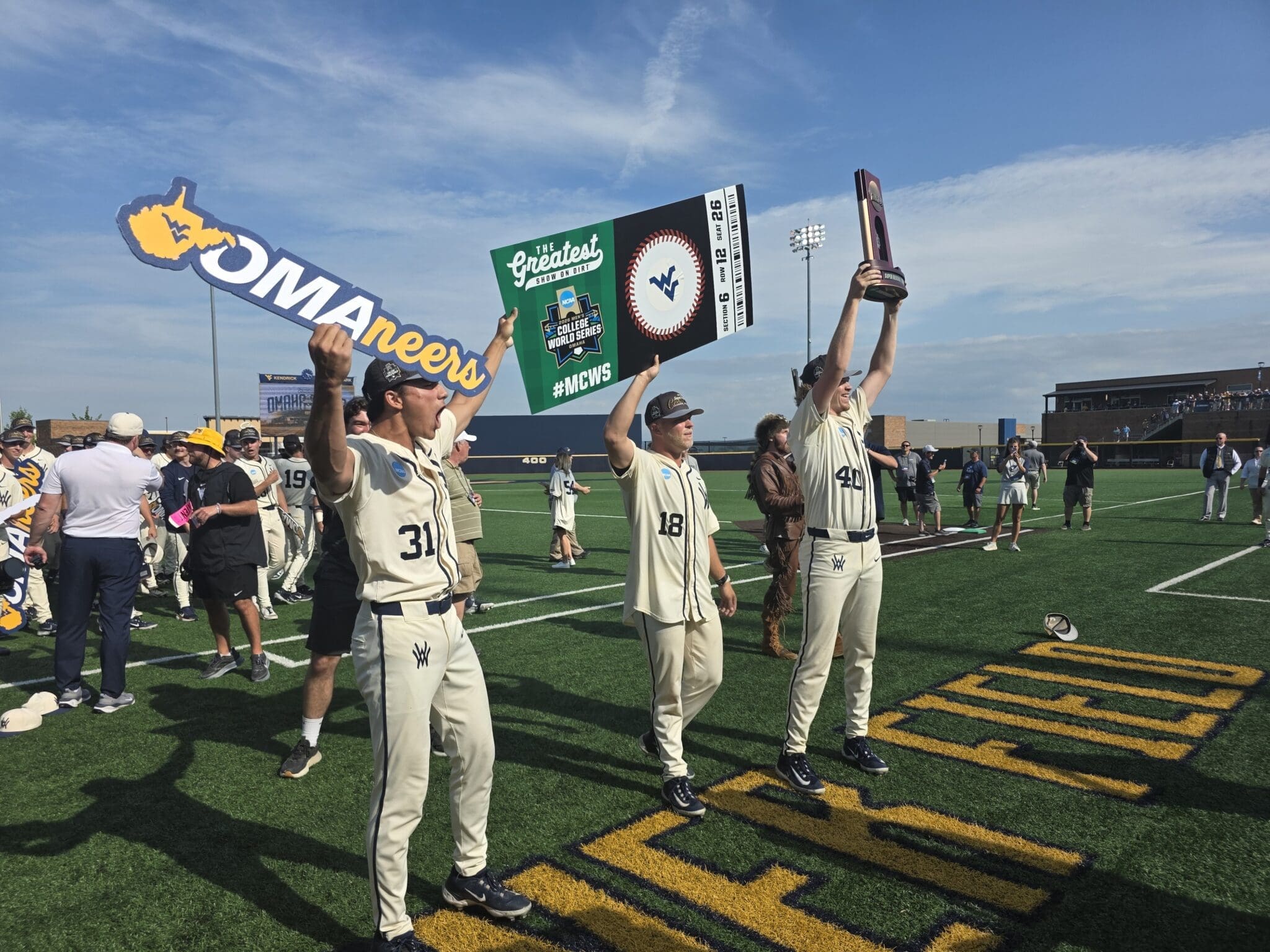 WVU Baseball celebrating Super Regional title with sign and trophy