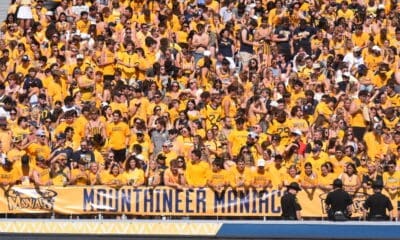 WVU Football fans in student section with Mountaineer Maniacs sign STOCK