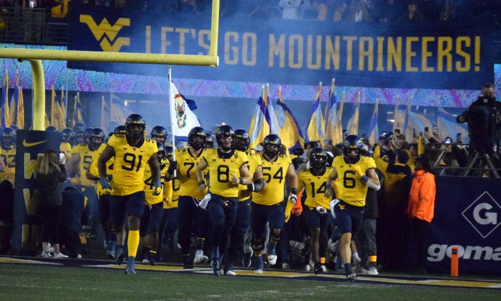 WVU Football team running on field Backyard Brawl