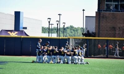 WVU Baseball players huddle on field before Morgantown Regional