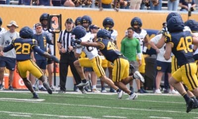 WVU Football players making a tackle during scrimmage with Troy Fischer in corner