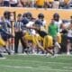 WVU Football players making a tackle during scrimmage with Troy Fischer in corner