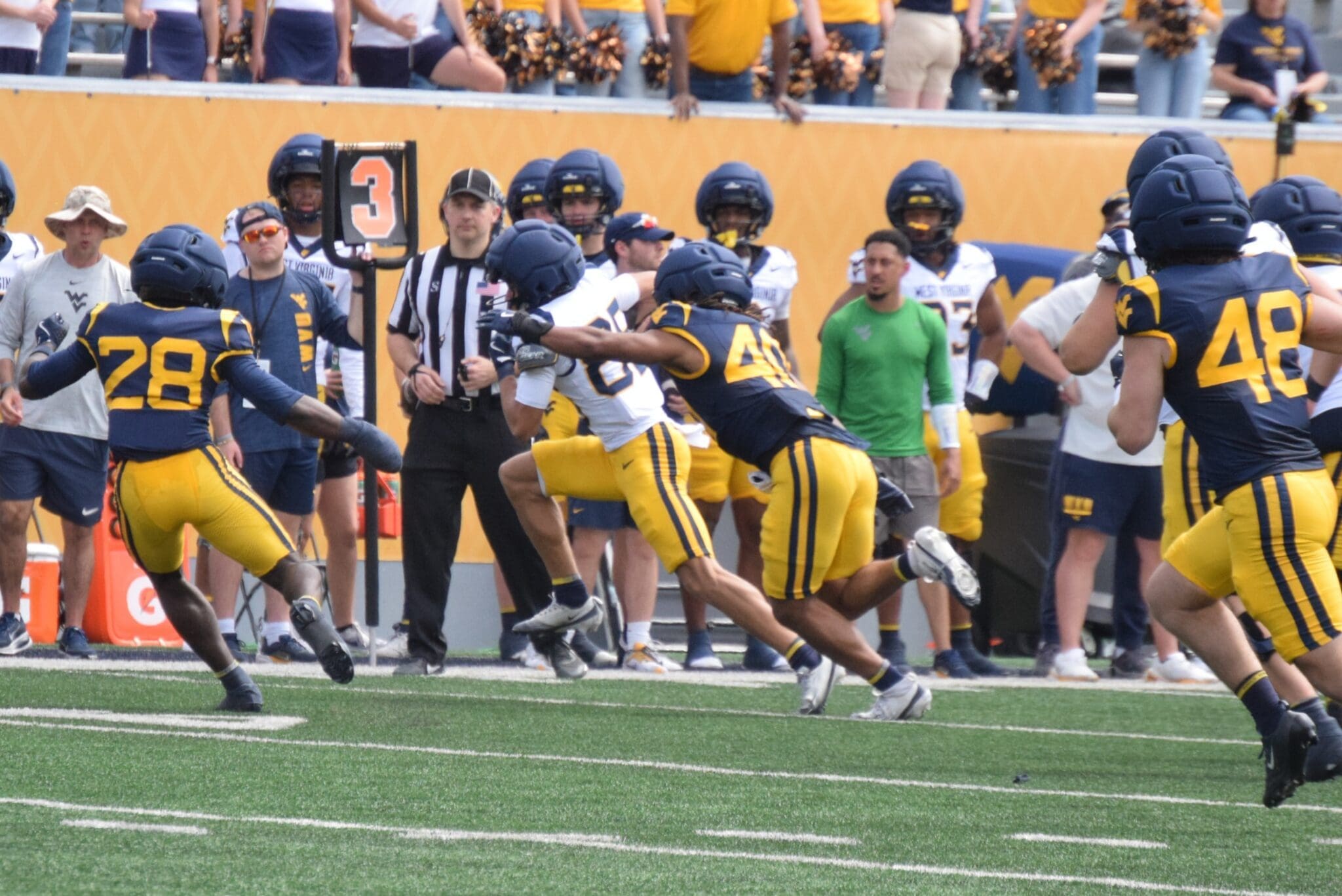 WVU Football players making a tackle during scrimmage with Troy Fischer in corner