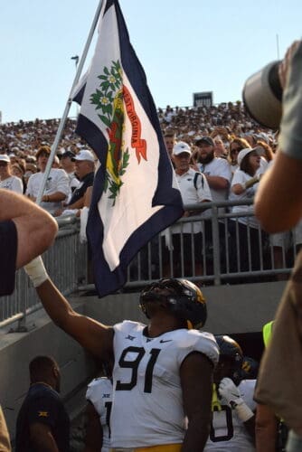 WVU Football Sean Martin waving state flag