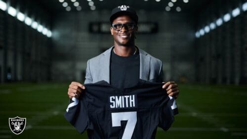 Geno Smith holding Raiders jersey