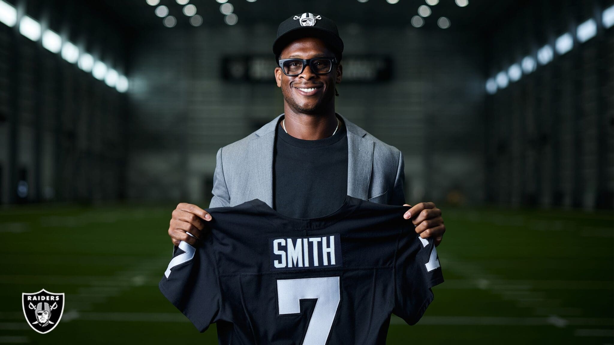 Geno Smith holding Raiders jersey