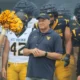 WVU Football HC Rich Rodriguez in front of team