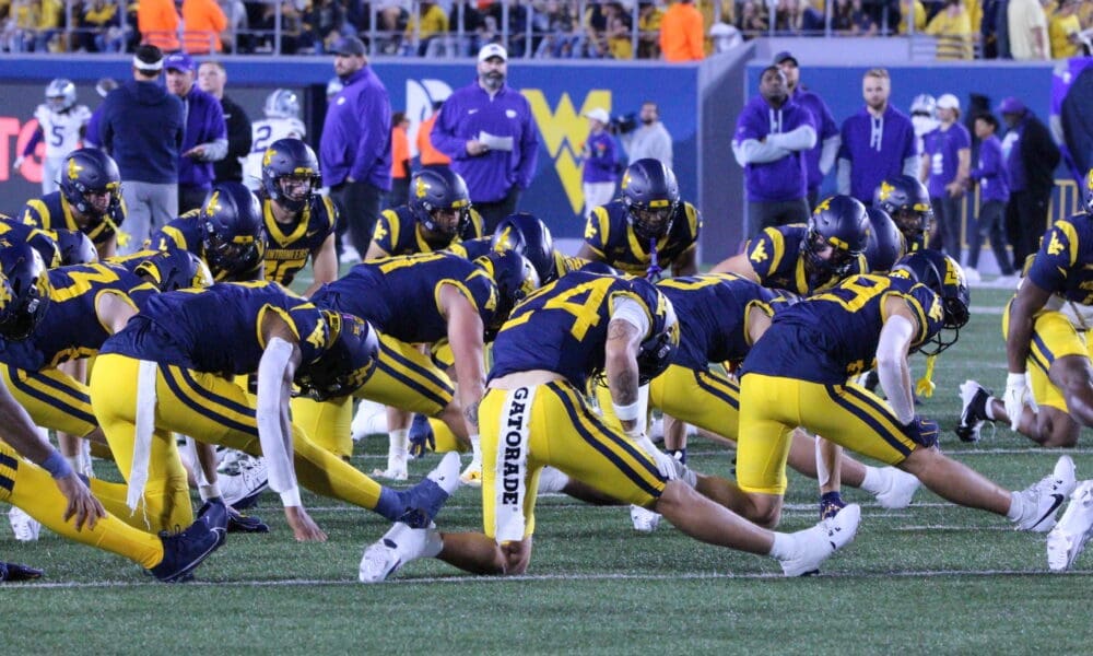 WVU Football team stretching stock photo with Rodney Gallagher