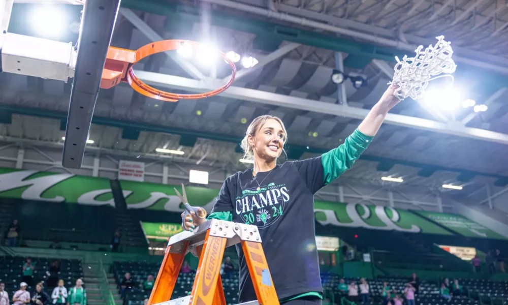 Kim Caldwell holding net after winning conference title with Marshall