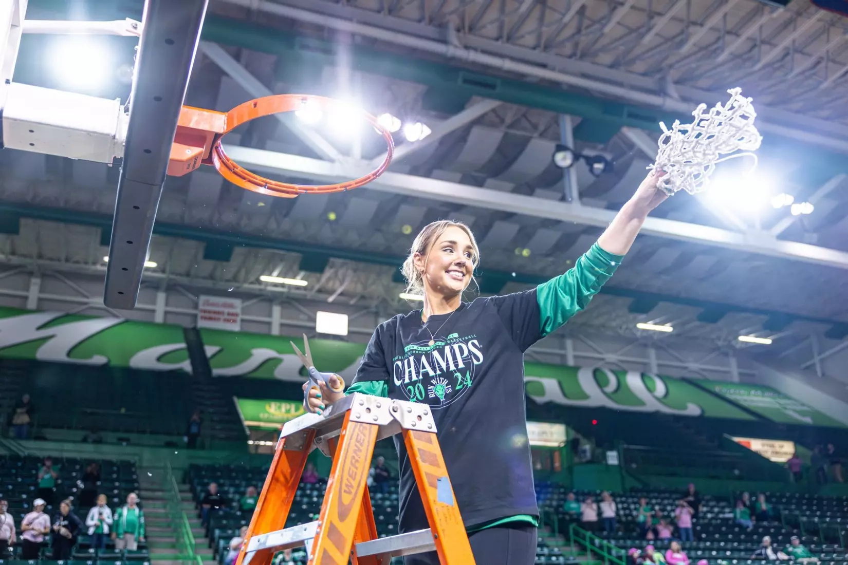 Kim Caldwell holding net after winning conference title with Marshall