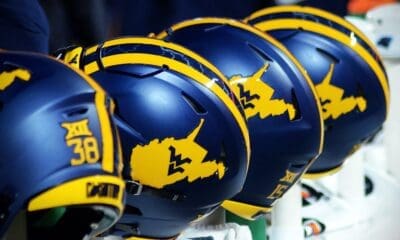 WVU Football helmets rest on the sideline stock
