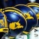 WVU Football helmets rest on the sideline stock