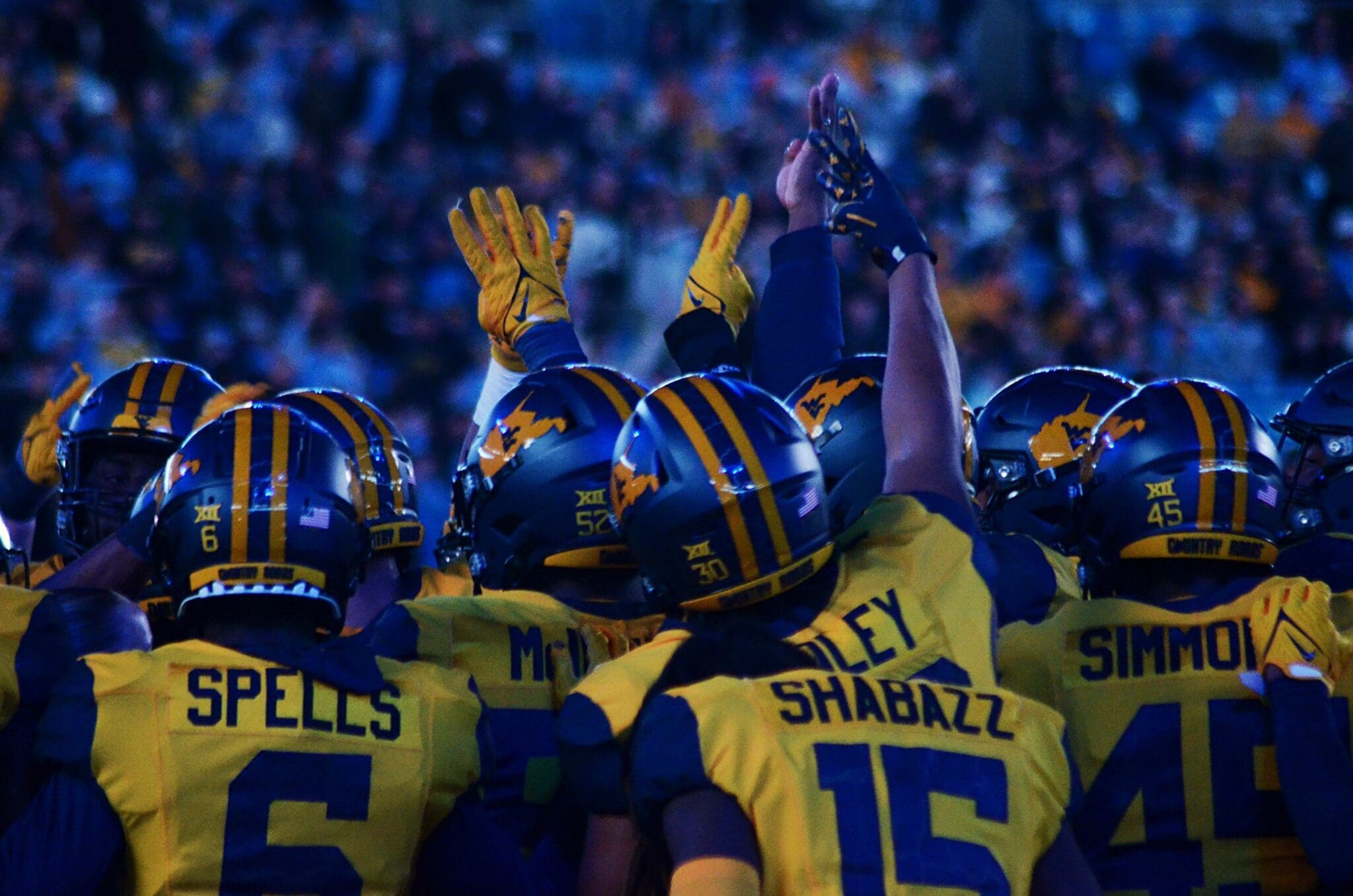 WVU Football players huddle up before the fourth quarter against UNC at the Duke's Mayo Bowl on Dec. 27, 2023, at Bank of America Stadium in Charlotte, N.C. (Mitchell Northam / WV Sports Now)