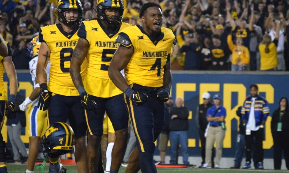 WVU Football Nicco Marchiol, CJ Donaldson with helmet off and Devin Carter